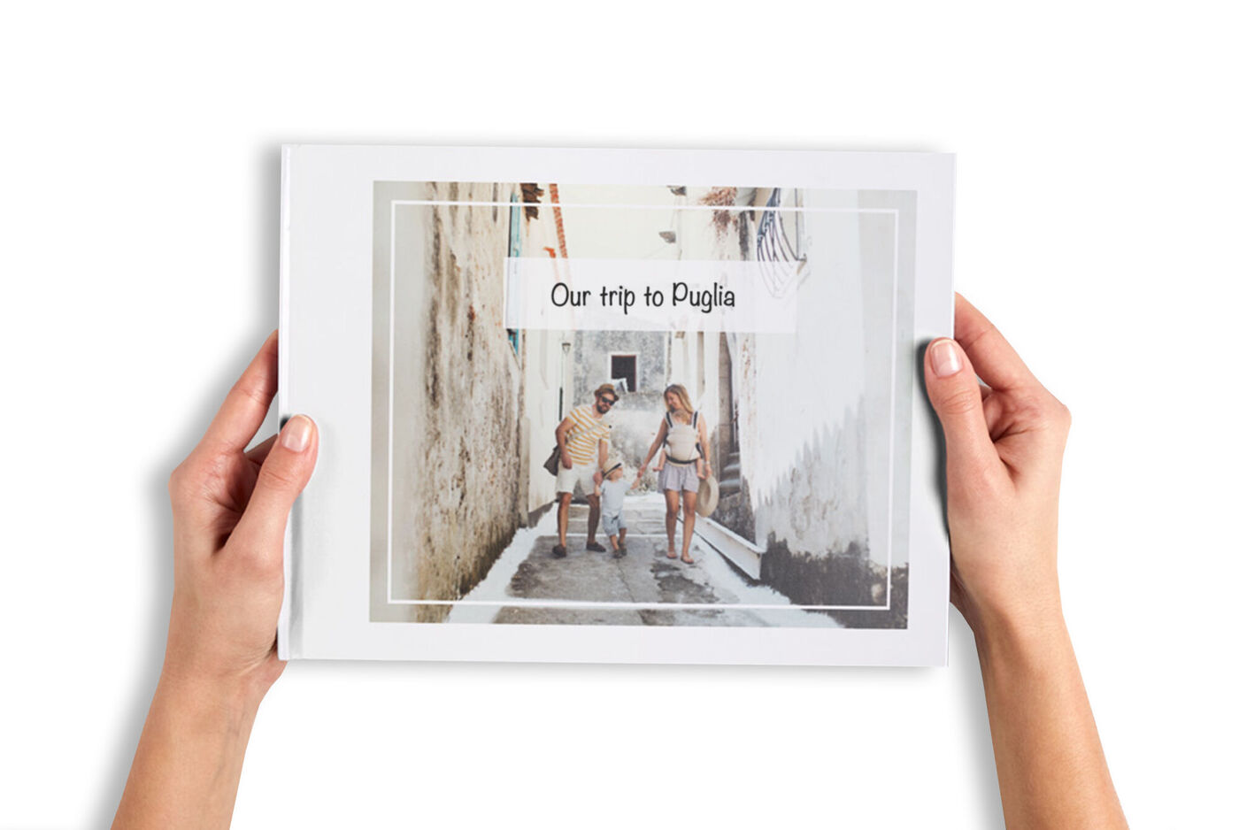 A couple holds a photo book titled 'Our trip to Puglia'. The street in the background is bright and friendly.
